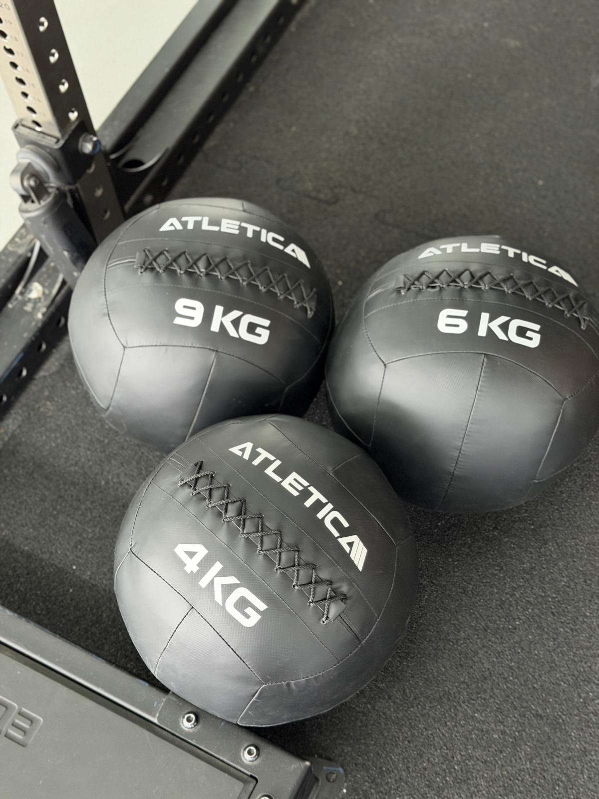 Drei Wall Balls in 4, 6 und 9 kg neben dem Rig im Functional-Fitness-Bereich des Invictus Gym Hamburg