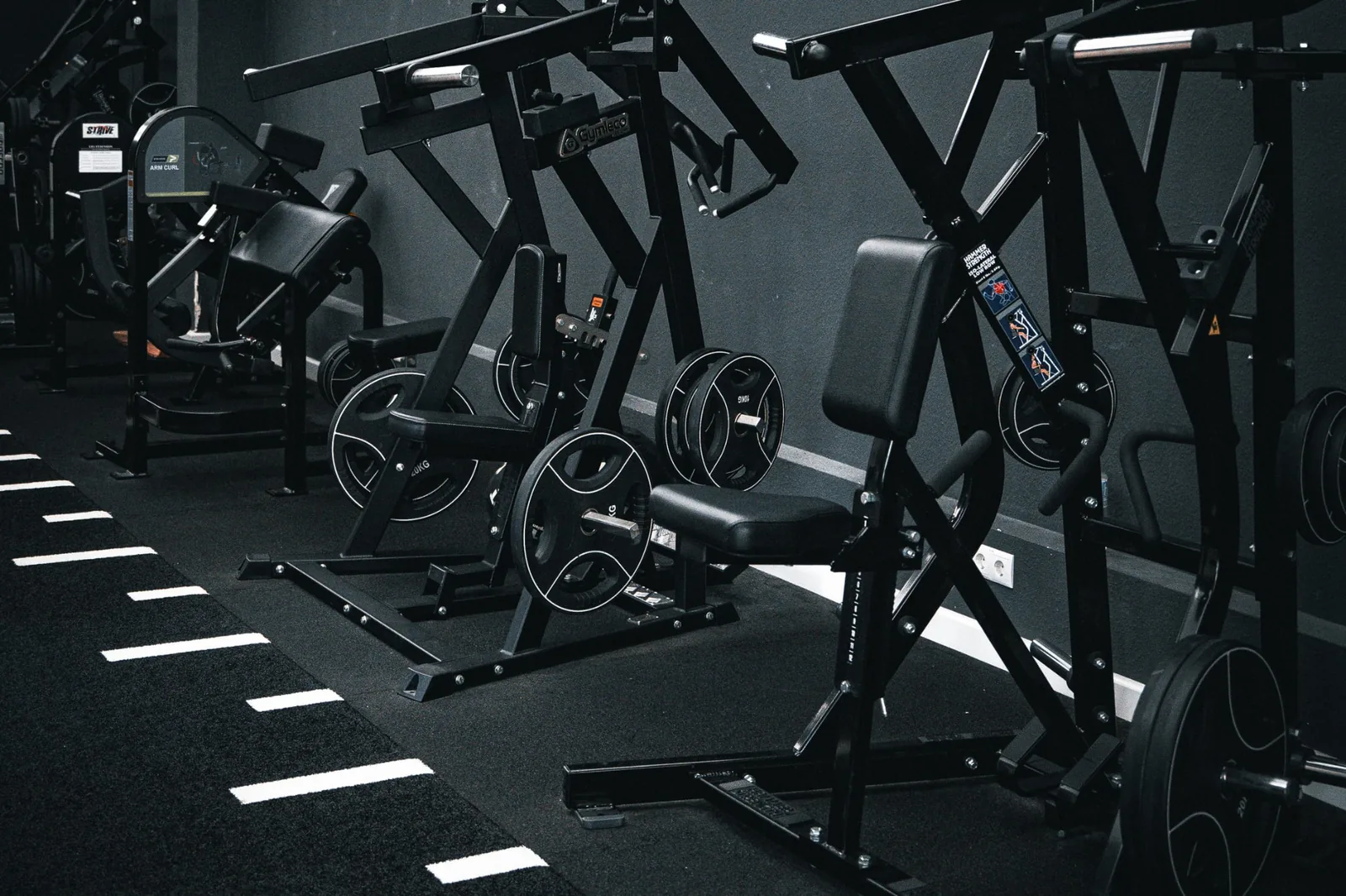 Reihe von Plate-Loaded Geräten im Gerätebereich des Invictus Gym Hamburg