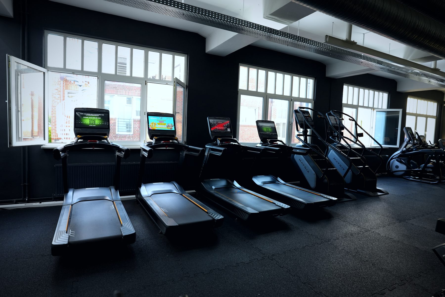 Cardiobereich mit Laufbändern an der Fensterfront im Invictus Gym Hamburg