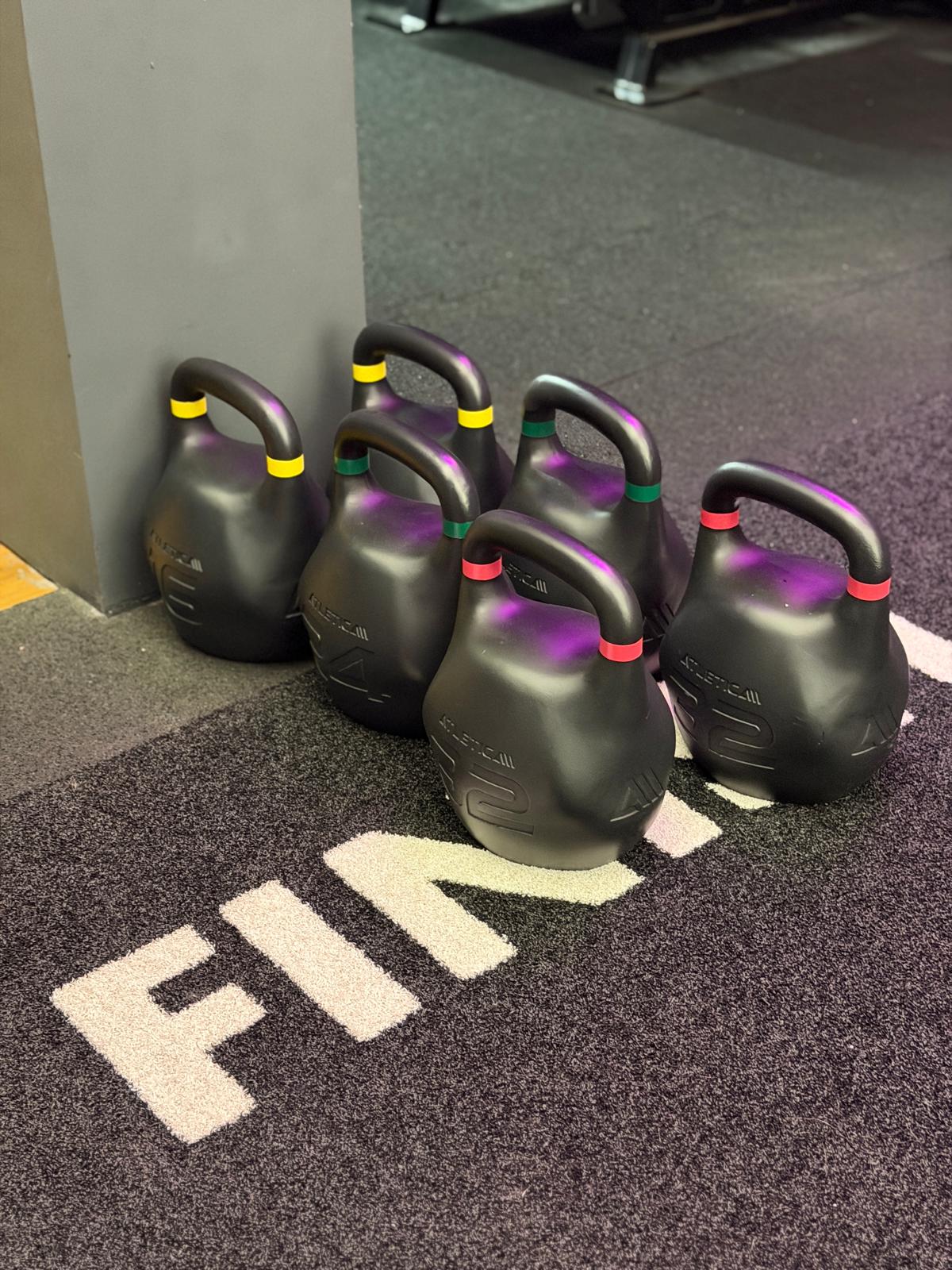 Reihe Competition-Kettlebells auf dem Kunstrasen im Functional-Fitness-Bereich des Invictus Gym Hamburg Bergedorf